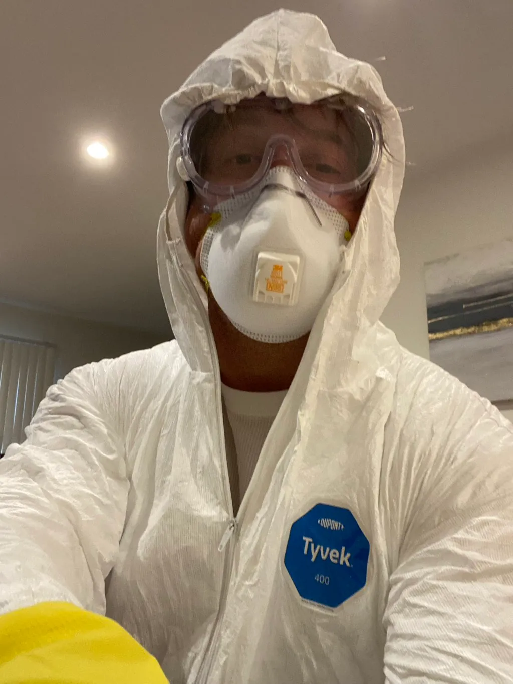A&A Property Inspections technician in Tyvek 400 suit and N95 respirator before entering an active remediation zone.